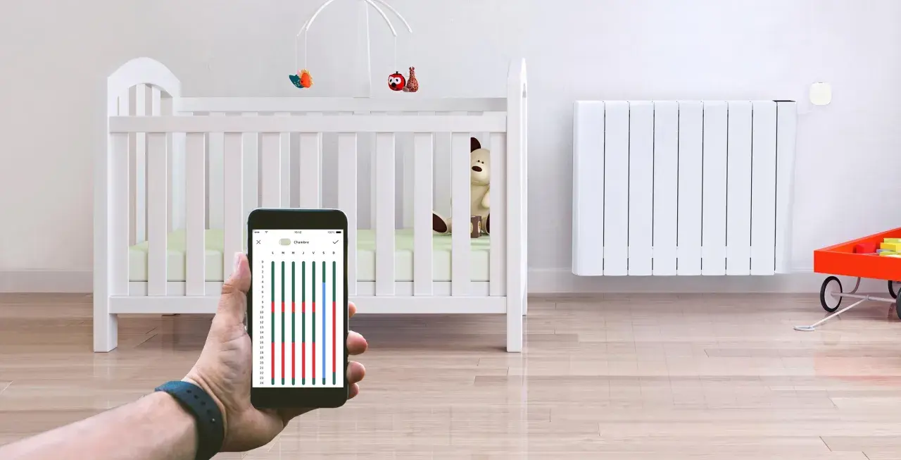 Contrôle du chauffage de la chambre bébé via smartphone. Un radiateur blanc et un lit de bébé sont visibles.