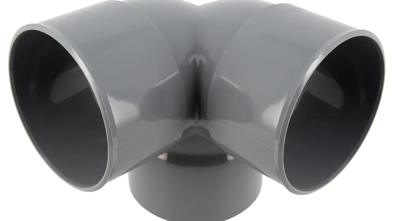 Un coude 1/2 femelle femelle gris en PVC, prêt à connecter deux tuyaux pour un système de plomberie.