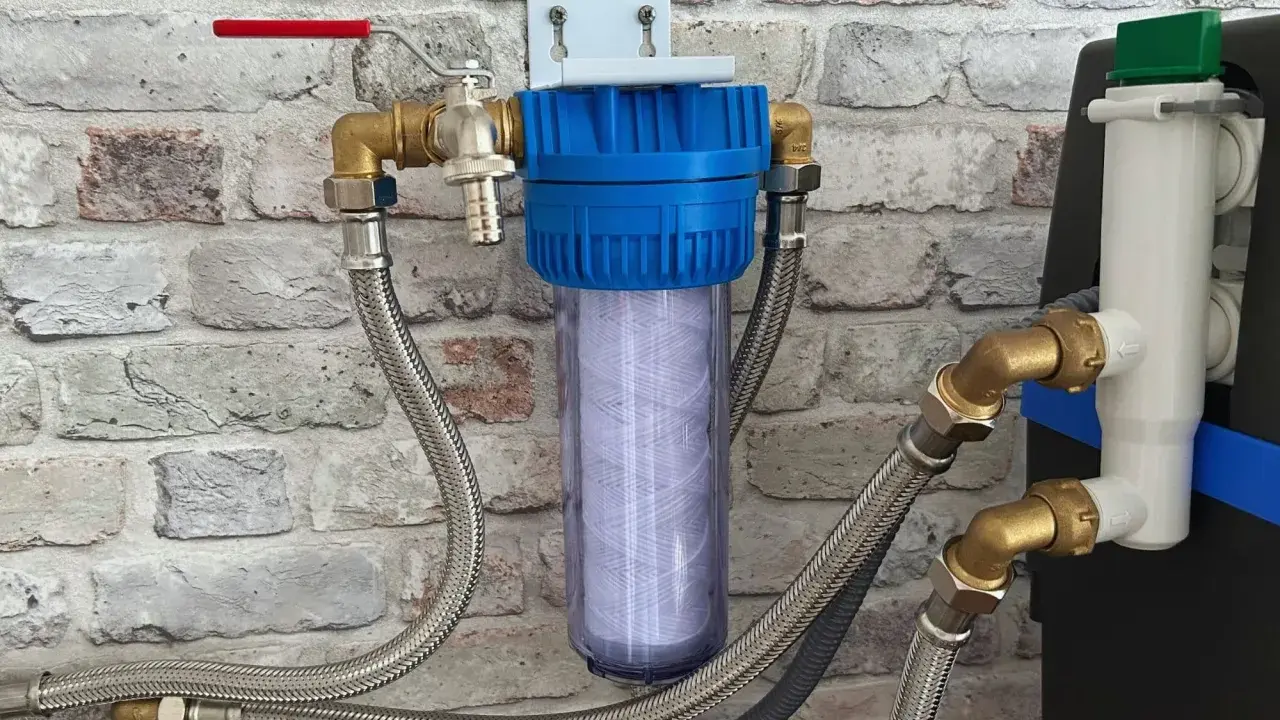 Système de filtration d'eau avec cartouche visible, raccordé à un adoucisseur. Un filtre avant adoucisseur obligatoire pour une eau pure.