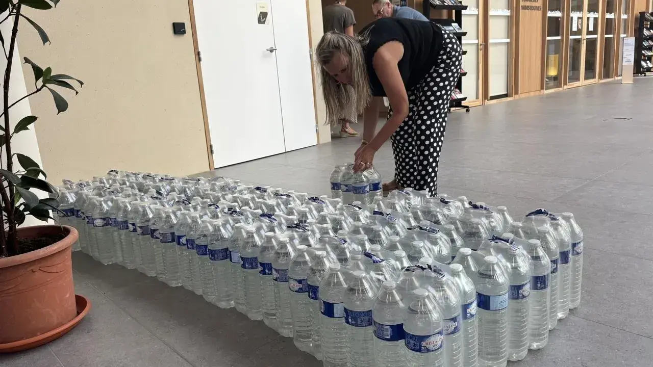 Une femme arrange des bouteilles d'eau potable, prêtes pour une distribution à Angers.