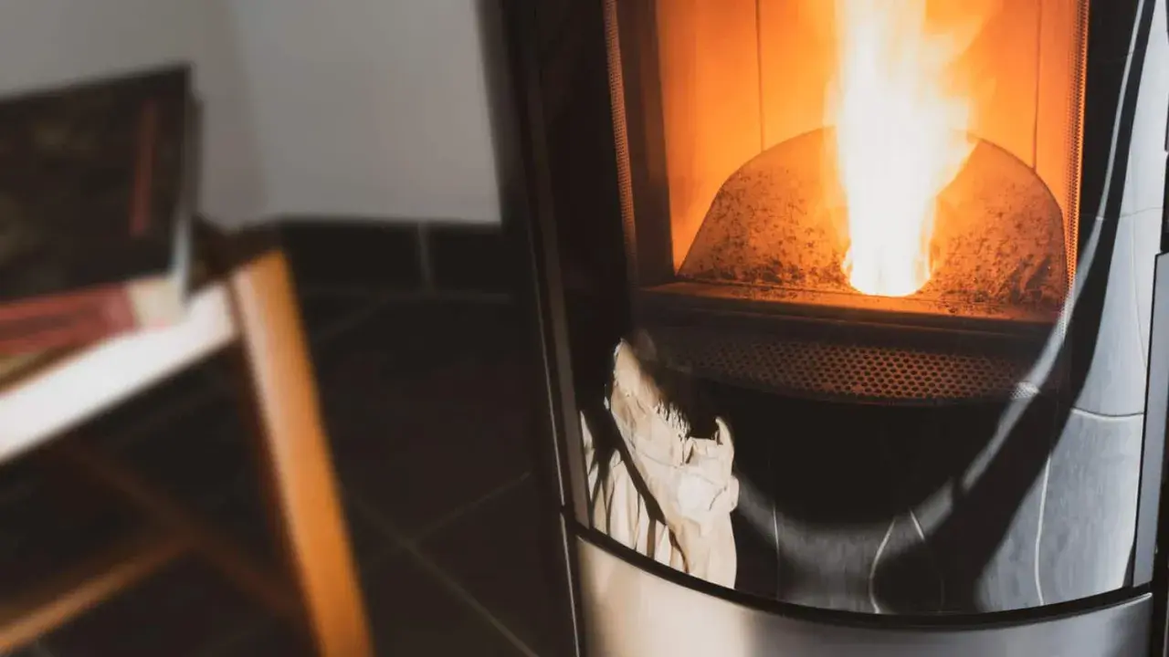 Poêle à pellets en feu, avec un sac en papier visible. Peut-être un problème extracteur de fumée poêle à pellet ?