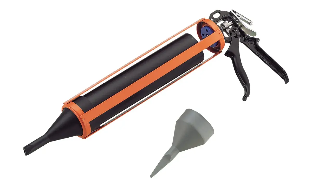 Pistolet à joint orange et noir, prêt à l'emploi pour vos travaux de calfeutrage. Un embout gris est également visible.