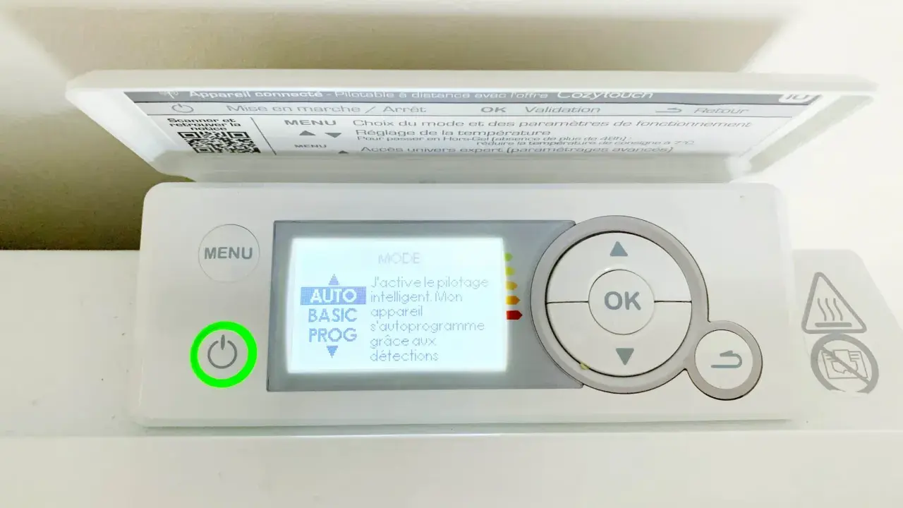 Thermostat sur radiateur électrique. L'écran affiche "MODE AUTO" pour un pilotage intelligent. Le bouton d'alimentation est allumé en vert.