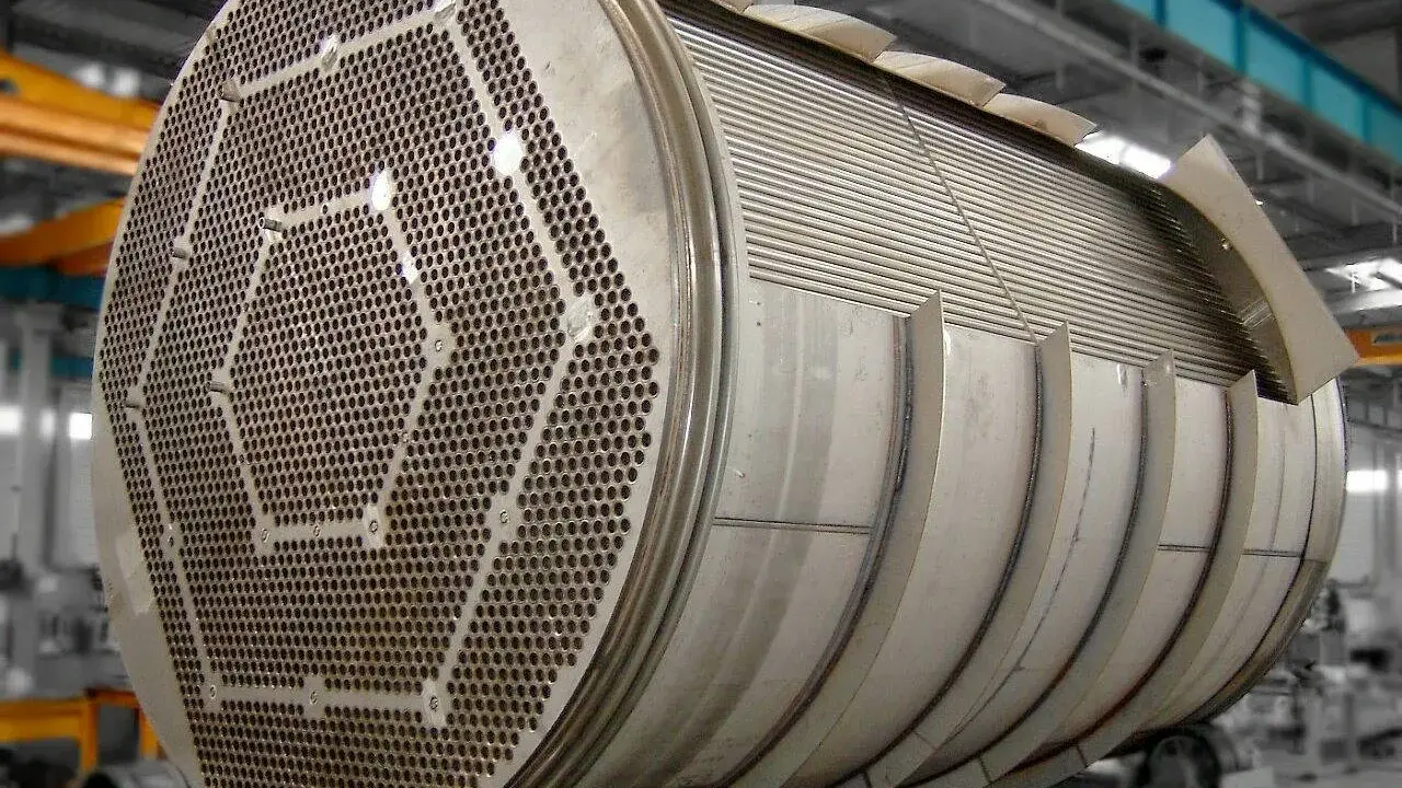 Gros plan sur un échangeur tubulaire inox, montrant sa plaque tubulaire perforée et son faisceau de tubes.