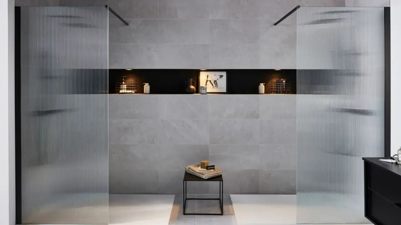 Une salle de bain moderne avec une douche et une baignoire, séparées par des parois en verre texturé.