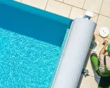 Un technicien nettoie le filtre de la pompe de piscine, un entretien essentiel pour optimiser la consommation d'énergie.