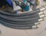 Plusieurs tuyaux hydrauliques BOTONG, chaque tuyau serti avec des raccords métalliques, prêts pour l'installation.