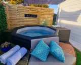 Ambiance relaxante autour d'un spa gonflable : coussins bleus, serviettes douces et guirlande lumineuse pour une deco parfaite.
