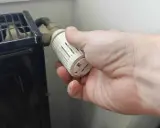 Main tenant ajuste le thermostat pour savoir quand éteindre le chauffage.