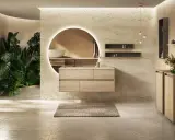 Une salle de bain moderne avec des plantes luxuriantes, un meuble vasque en bois flottant et un miroir rond lumineux. Une belle inspiration salle de bain.