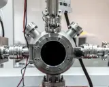 Gros plan sur un équipement de laboratoire complexe, avec une bride tournante inox au centre, connectée à divers tuyaux et raccords métalliques.