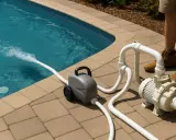 Pompe de piscine avec tuyaux et jet d'eau dans la piscine.