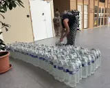 Une femme arrange des bouteilles d'eau potable, prêtes pour une distribution à Angers.