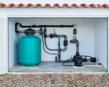 Système de filtration de piscine compact, une solution locale pour une piscine de 2m². Tuyauterie, pompe et réservoir turquoise.