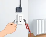 Main tenant modifie une prise électrique pour la transformer en prise radiateur, avec des pinces et un adaptateur.