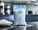 Un sachet de sel pour adoucisseur d'eau, avec une assiette de sel à côté. Idéal pour une consommation maîtrisée.