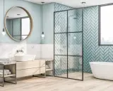 Salle de bain moderne avec baignoire, douche et lavabo. Le mur de la douche est décoré de carreaux bleu sarcelle posés en chevrons.