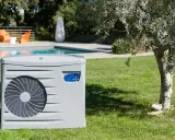 Pompe à chaleur pour piscine, élément clé d'un schéma de filtration performant, installée sur une pelouse verdoyante près d'une piscine.