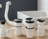 Ensemble de bondes de silicone pour évier, avec tuyau de vidange flexible et bouchons noirs et chromés.