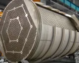 Gros plan sur un échangeur tubulaire inox, montrant sa plaque tubulaire perforée et son faisceau de tubes.