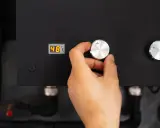 Main d'une personne ajustant le bouton d'une pompe à chaleur connectée affichant 48°C.