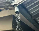 Gouttière en métal sous une pluie battante, l'eau s'écoule abondamment du tuyau, assurant l'évacuation eau de pluie.