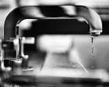 Gouttes d'eau tombant d'un robinet, évoquant la dureté de l'eau à Lyon.