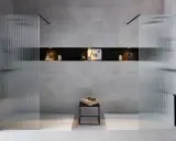 Une salle de bain moderne avec une douche et une baignoire, séparées par des parois en verre texturé.