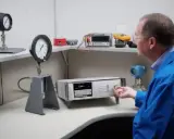 Un technicien effectue l'étalonnage d'un manomètre à l'aide d'un appareil de mesure de précision.