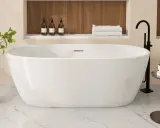 Une élégante baignoire îlot blanche, prête pour un moment de détente. La pose baignoire est mise en valeur par des accessoires de salle de bain modernes.