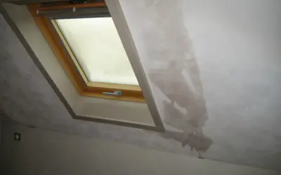 Gouttes d'eau sur le mur d'une maison non chauffée, près d'une fenêtre de toit. La condensation s'accumule et coule.