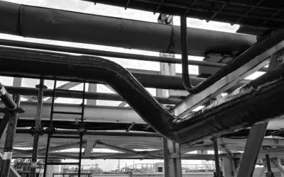 Gros plan sur des tuyaux industriels, certains recouverts d'une texture rugueuse suggérant un colmatage ou une isolation.
