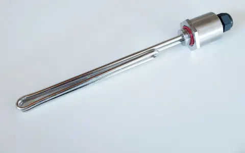 Élément chauffant en acier inoxydable, une résistance chauffante immergée avec un raccord fileté et un capuchon de protection.