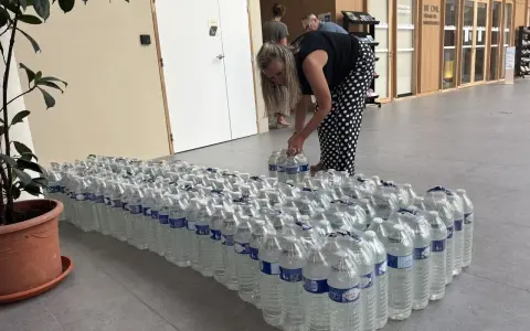 Une femme arrange des bouteilles d'eau potable, prêtes pour une distribution à Angers.