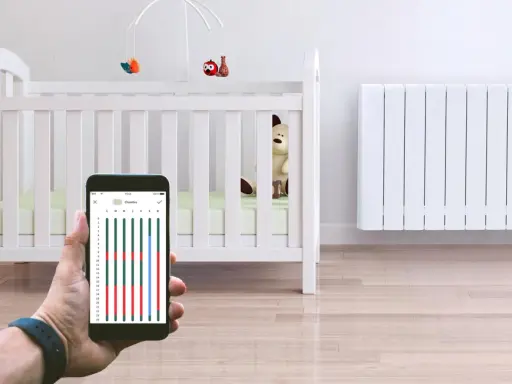 Contrôle du chauffage de la chambre bébé via smartphone. Un radiateur blanc et un lit de bébé sont visibles.