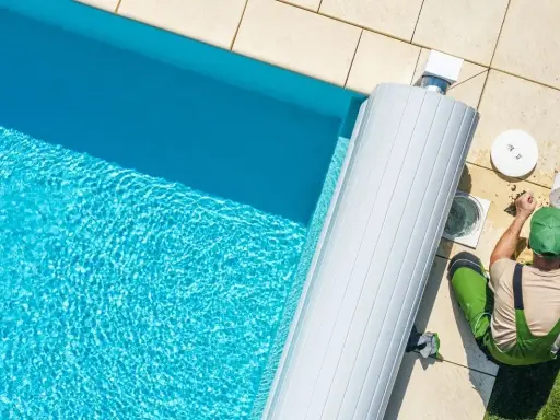 Un technicien nettoie le filtre de la pompe de piscine, un entretien essentiel pour optimiser la consommation d'énergie.