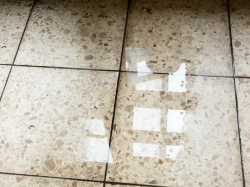 Eau sur le sol d'une maison, reflétant la lumière. L'isolation du sol est compromise.