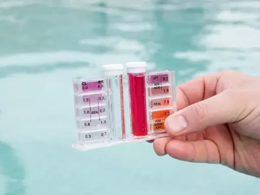 Testeur de piscine mesurant le chlore et le pH. La couleur rouge indique un niveau de chlore élevé, suggérant qu'il faut enlever le chlore de l'eau.