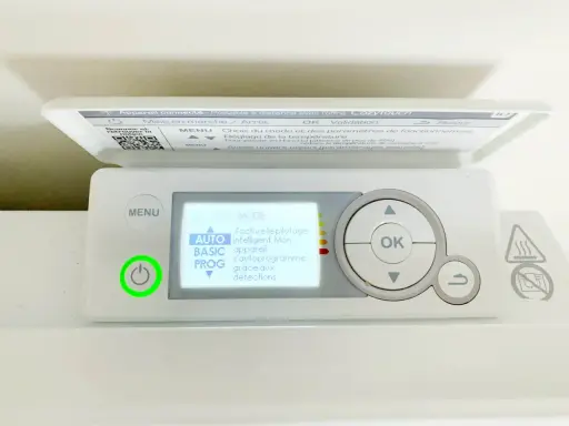 Thermostat sur radiateur électrique. L'écran affiche "MODE AUTO" pour un pilotage intelligent. Le bouton d'alimentation est allumé en vert.
