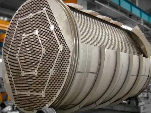 Gros plan sur un échangeur tubulaire inox, montrant sa plaque tubulaire perforée et son faisceau de tubes.