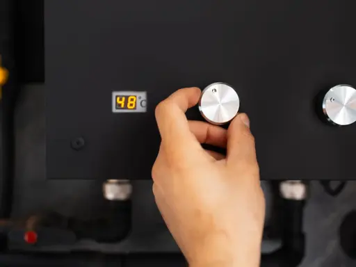 Main d'une personne ajustant le bouton d'une pompe à chaleur connectée affichant 48°C.