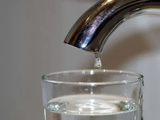 Une goutte d'eau potable de Rouen tombe dans un verre.