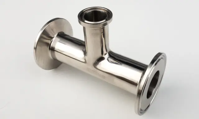 Un raccord clamp en acier inoxydable, en forme de T, prêt à être assemblé pour un système de tuyauterie.