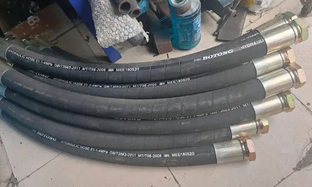 Plusieurs tuyaux hydrauliques BOTONG, chaque tuyau serti avec des raccords métalliques, prêts pour l'installation.