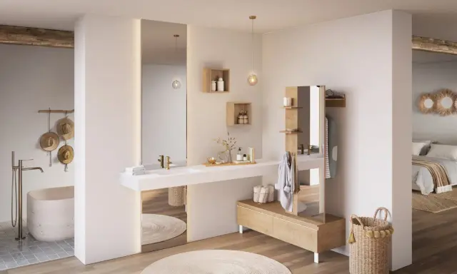 Salle de bain ouverte sur chambre, avec baignoire, lavabo, et dressing. Ambiance épurée et naturelle.