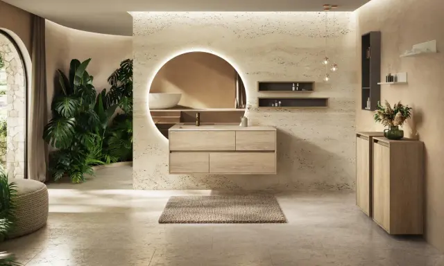 Une salle de bain moderne avec des plantes luxuriantes, un meuble vasque en bois flottant et un miroir rond lumineux. Une belle inspiration salle de bain.