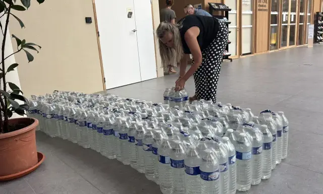 Une femme arrange des bouteilles d'eau potable, prêtes pour une distribution à Angers.