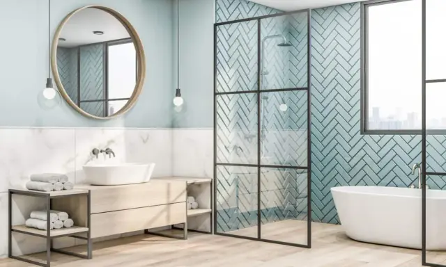 Salle de bain moderne avec baignoire, douche et lavabo. Le mur de la douche est décoré de carreaux bleu sarcelle posés en chevrons.