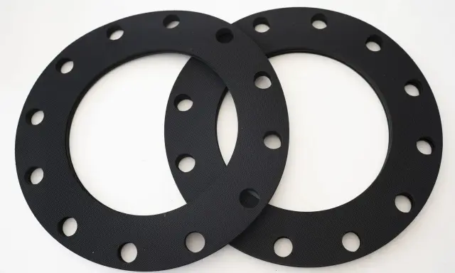Deux joints sbr noirs, circulaires et percés, prêts à assurer l'étanchéité d'une connexion.