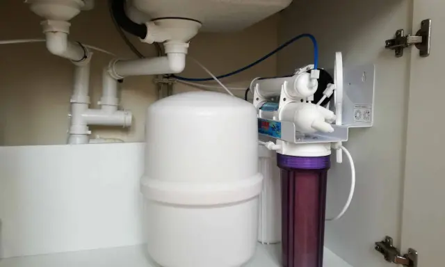 Système de filtration d'eau sous évier avec réservoir et cartouche violette. Installation pour l'évacuation adoucisseur d'eau.